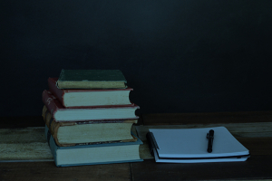 Stack of books on a wooden table.