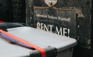 Sign Saying "Rent Me" with storage bin in front of it