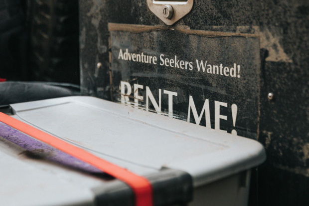 Sign Saying "Rent Me" with storage bin in front of it