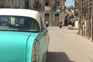 Image of a turquoise 1950's car on a street in Havana, Cuba