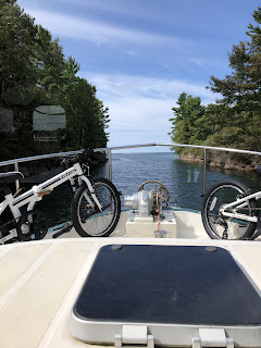 View of bicycles on the front of a boat on a lake. 