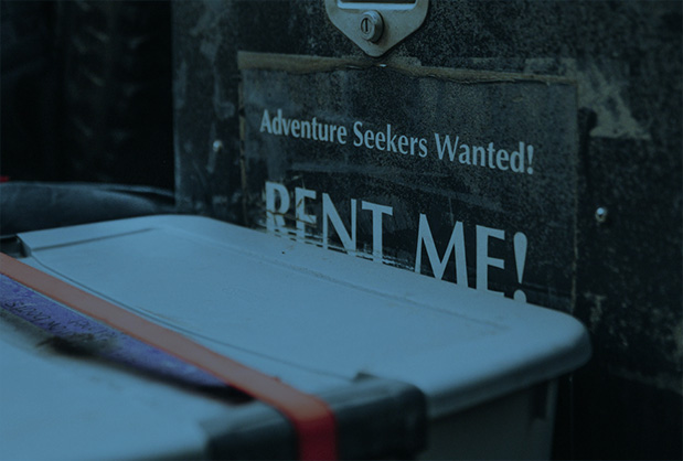 Sign Saying "Rent Me" with storage bin in front of it.