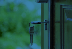 A front door of a home being opened with a key.