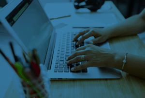 A person typing on a laptop computer